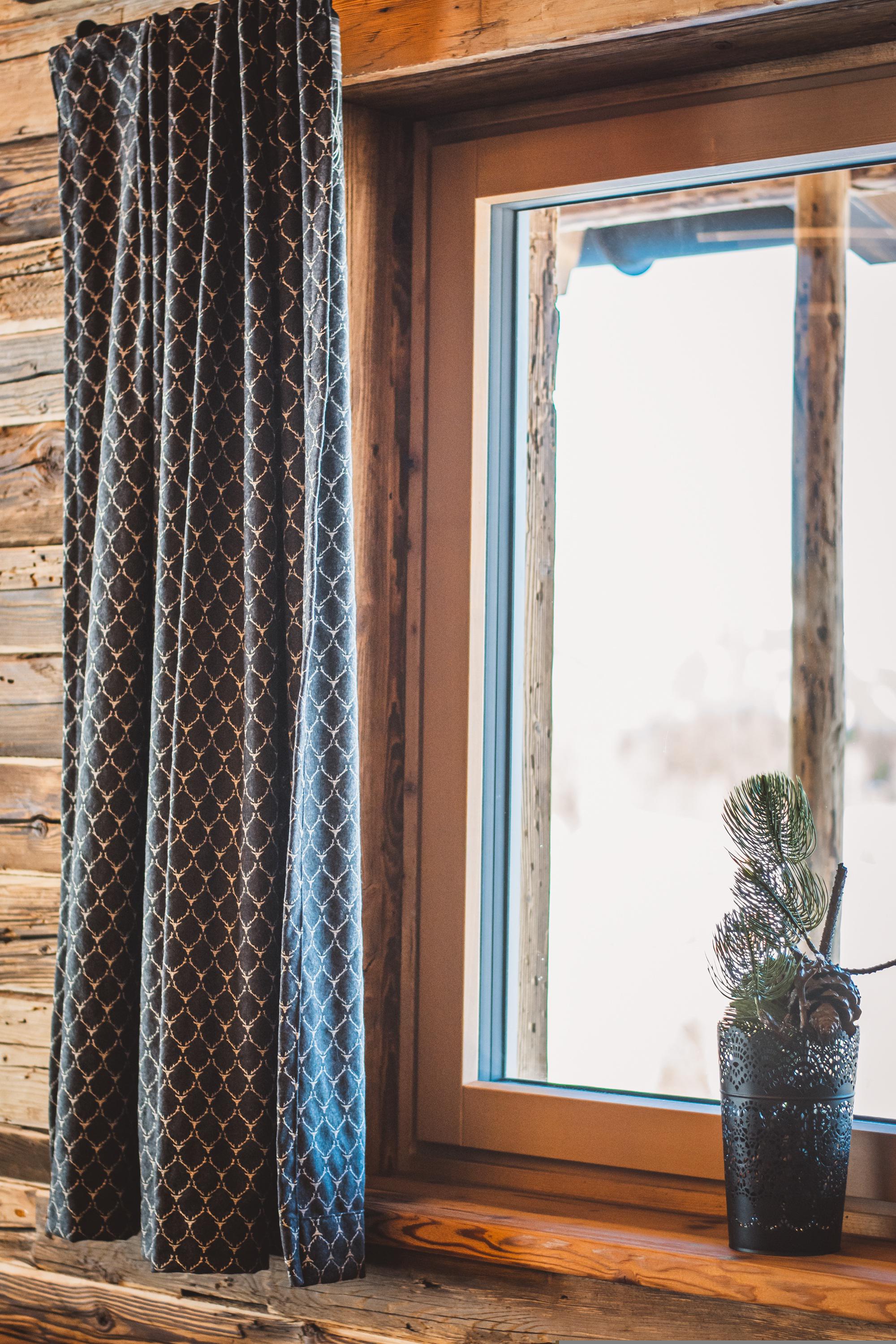 Patterned curtain hanging beside a window